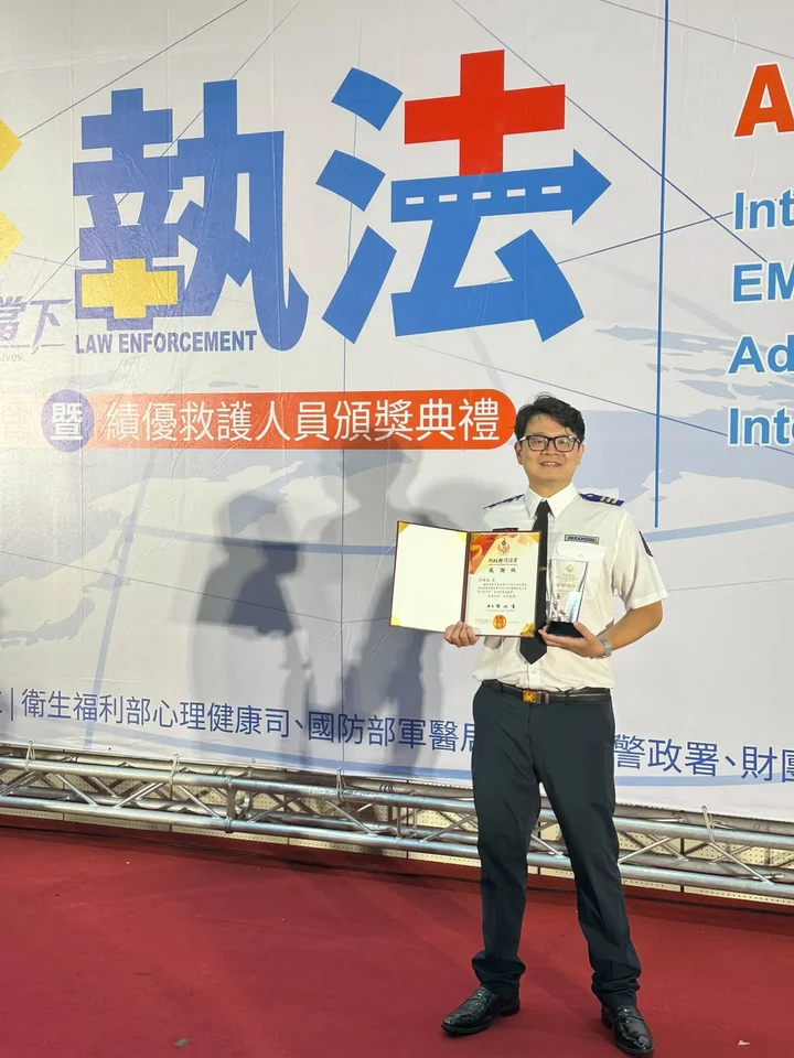 在消防署救護日頒獎典禮現場，手持獎狀與獎座留影
